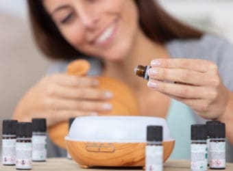 woman dripping essential oils into a diffuser