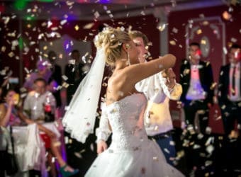 blonde bride dancing at restaurant in flying confetti
