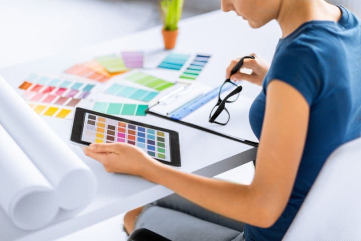 How Much Does It Cost to Hire an Interior Designer? woman working with color samples for selection